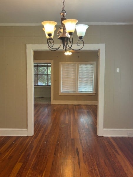 407 N Ridge Ave, Tifton, GA 31794 - unfurnished dining area featuring baseboards, dark wood-style flooring, a chandelier, and ornamental molding