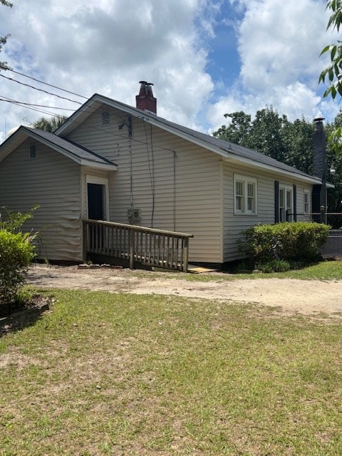 407 N Ridge Ave, Tifton, GA 31794 - rear view of house featuring a chimney, a yard, and a wooden deck