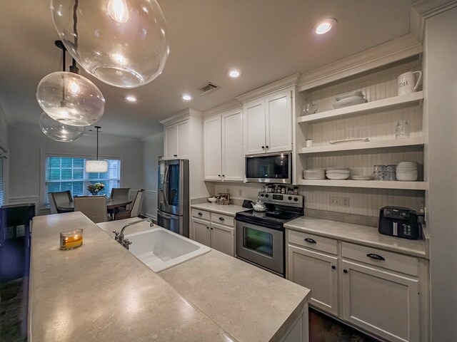 74 Surrey Cir, Tifton, GA 31793 - kitchen with stainless steel appliances, white cabinetry, crown molding, open shelves, and decorative light fixtures