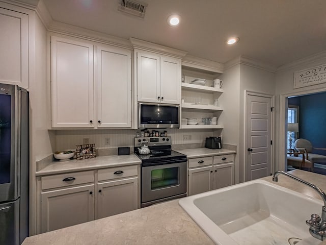 74 Surrey Cir, Tifton, GA 31793 - kitchen featuring appliances with stainless steel finishes, light countertops, white cabinets, crown molding, and open shelves