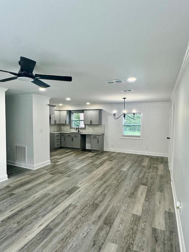 702 N Livingston St, Sylvester, GA 31791 - unfurnished living room featuring wood finished floors, crown molding, a chandelier, a ceiling fan, and recessed lighting