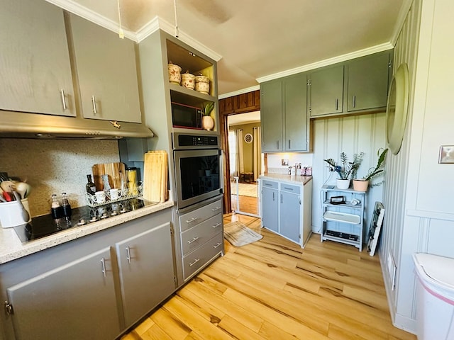 kitchen with green cabinetry, black electric stovetop, light wood-style floors, ornamental molding, and stainless steel oven