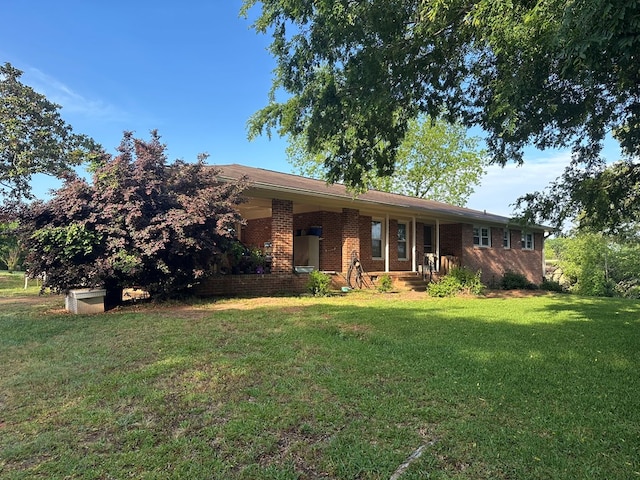 single story home with a porch, a front yard, and brick siding