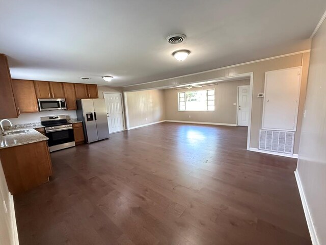 2411 Davis Ave, Tifton, GA 31794 - kitchen featuring appliances with stainless steel finishes, dark wood-type flooring, brown cabinets, light countertops, and open floor plan