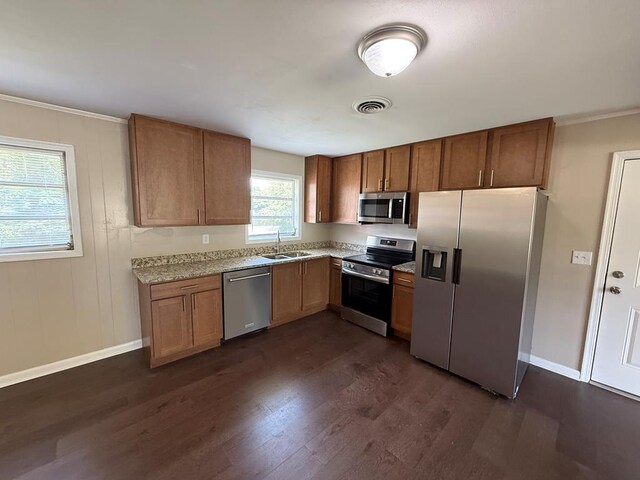 2411 Davis Ave, Tifton, GA 31794 - kitchen with stainless steel appliances, dark wood-type flooring, light countertops, crown molding, and brown cabinets