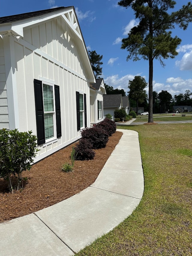 view of property exterior featuring board and batten siding and a yard