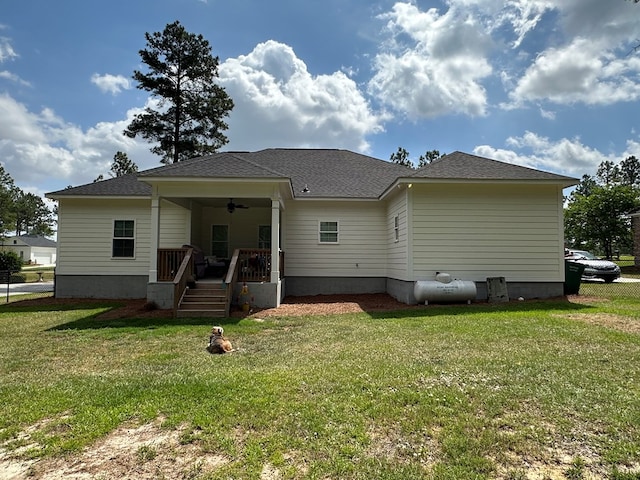back of house featuring a lawn, a ceiling fan, covered porch, and a shingled roof