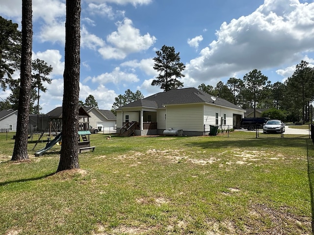 view of property exterior featuring a playground, fence, and a yard