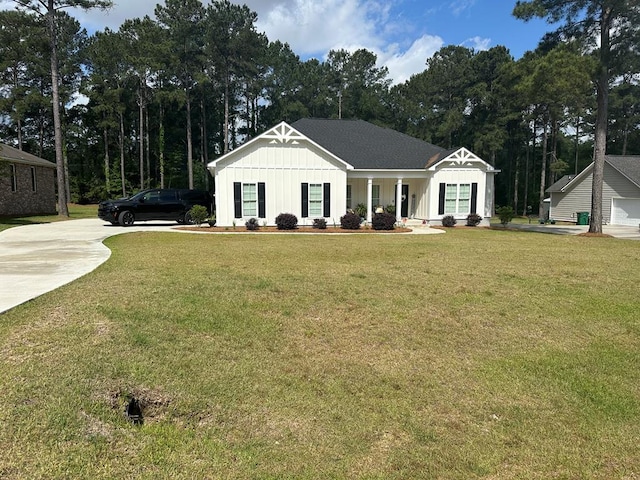 view of front of home with board and batten siding, concrete driveway, a porch, and a front yard