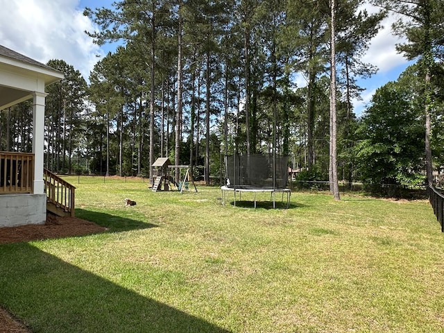 view of yard with a fenced backyard, a trampoline, and a playground