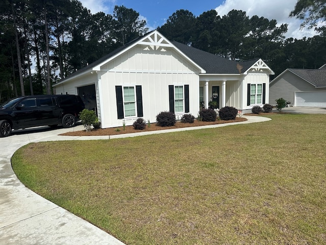 view of front of property featuring a garage, board and batten siding, and a front yard