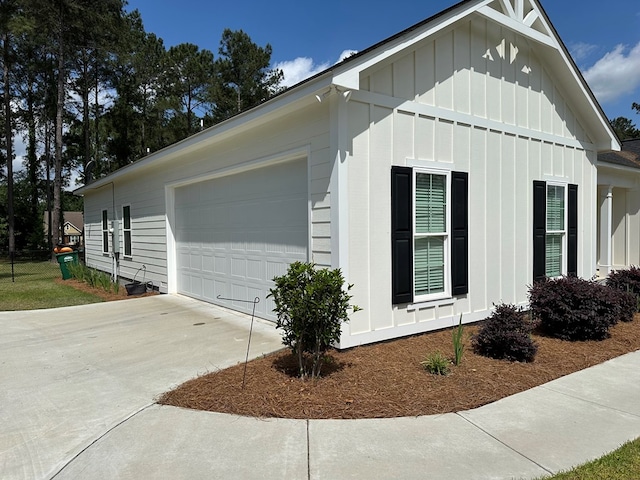 view of side of home with a garage, board and batten siding, and concrete driveway