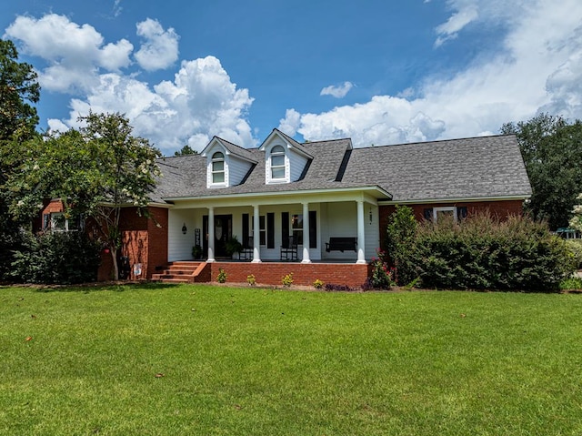 114 Creole Ct, Fitzgerald, GA 31750 - new england style home with a front lawn, a porch, a shingled roof, and brick siding