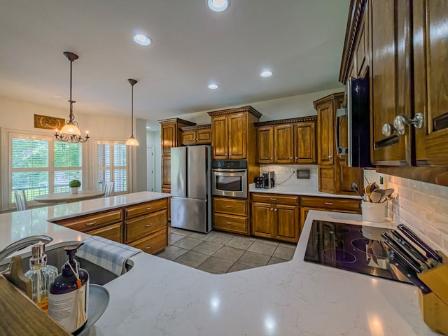 114 Creole Ct, Fitzgerald, GA 31750 - kitchen with stainless steel appliances, tasteful backsplash, brown cabinetry, light tile patterned flooring, and a chandelier