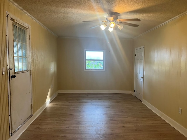 spare room with crown molding, wood finished floors, a ceiling fan, and a textured ceiling