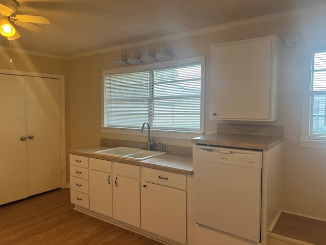 kitchen with white dishwasher, a sink, crown molding, and light wood finished floors
