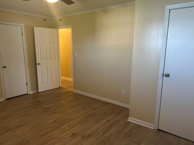 unfurnished bedroom featuring baseboards, ornamental molding, a ceiling fan, and wood finished floors