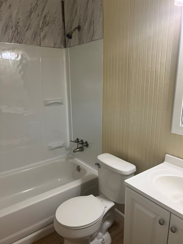 bathroom featuring toilet, vanity, and  shower combination