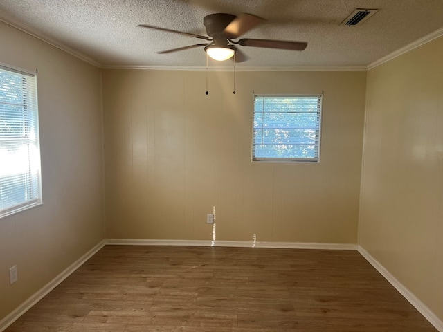 unfurnished room featuring crown molding, wood finished floors, ceiling fan, and plenty of natural light