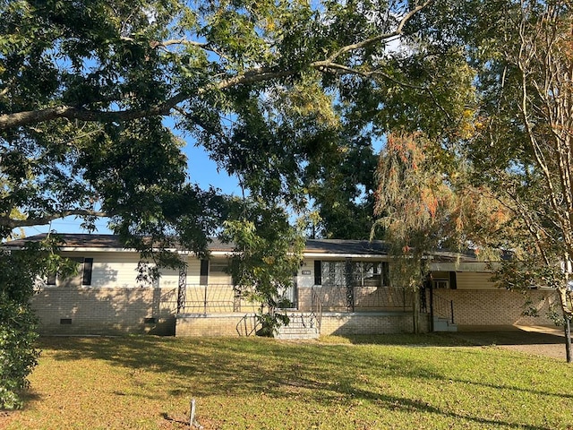 view of front of property with brick siding, a front lawn, and crawl space
