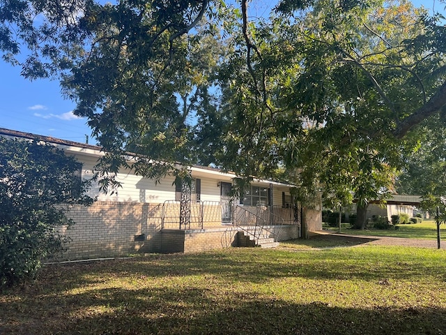 rear view of property featuring a porch and a yard