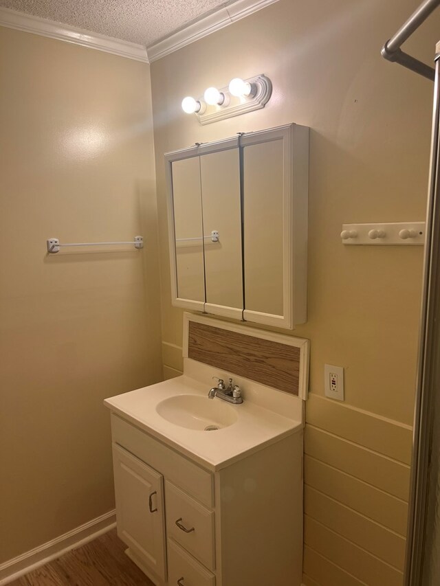 bathroom with a textured ceiling, vanity, and crown molding