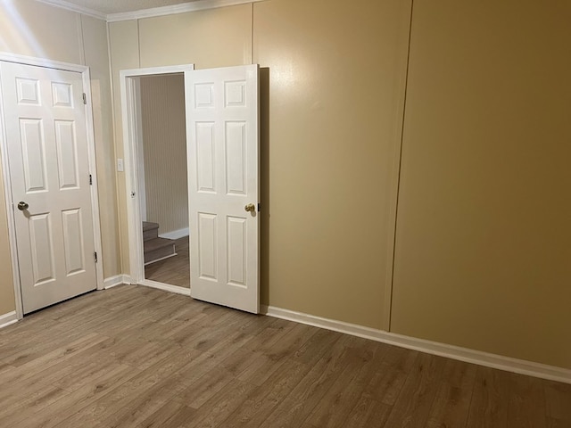 unfurnished bedroom featuring wood finished floors and baseboards