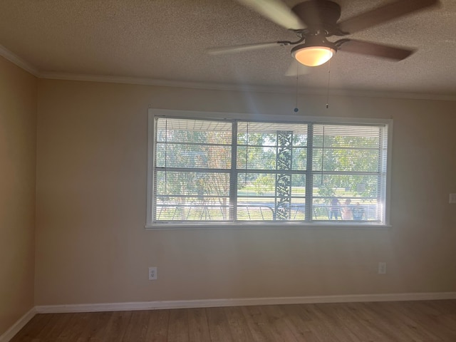 spare room with ornamental molding, a ceiling fan, wood finished floors, and a textured ceiling