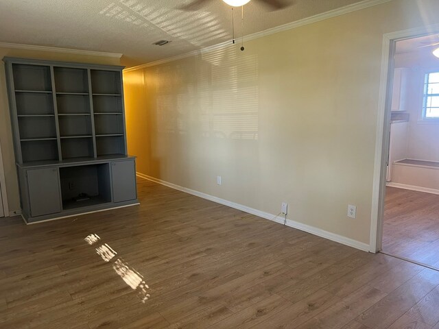 unfurnished living room featuring crown molding, ceiling fan, wood finished floors, and baseboards