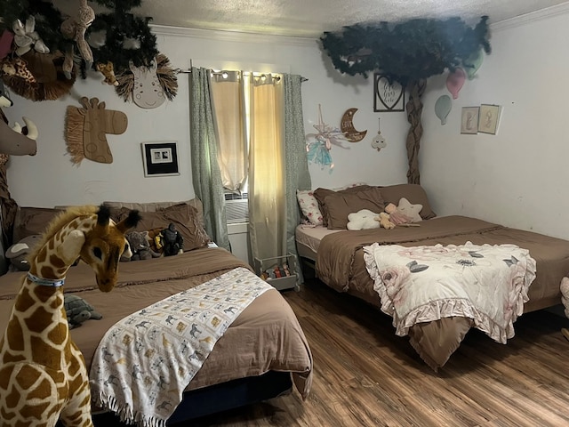 bedroom with ornamental molding, wood finished floors, and a textured ceiling