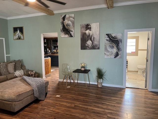 living room with crown molding, beam ceiling, baseboards, and wood finished floors