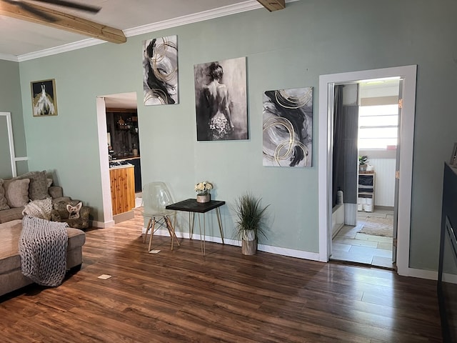 living room with baseboards, ornamental molding, beam ceiling, and wood finished floors