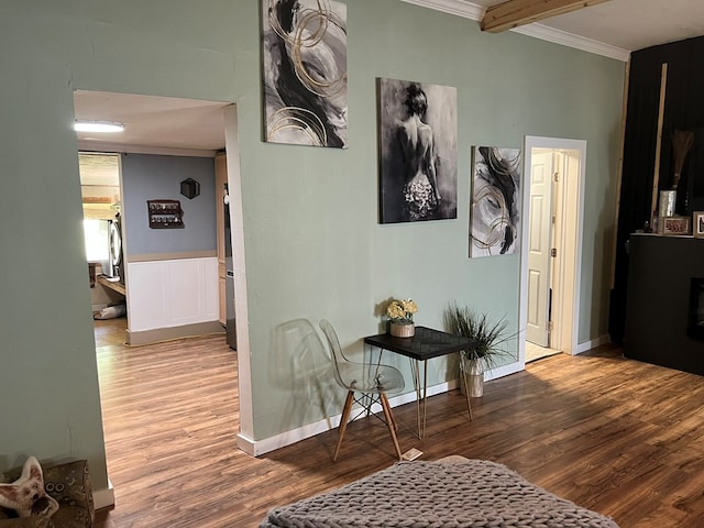 hallway featuring crown molding, wood finished floors, baseboards, and beam ceiling