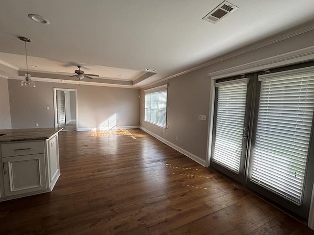564 Osprey Cir, Tifton, GA 31794 - unfurnished living room with crown molding, a tray ceiling, dark wood-type flooring, and ceiling fan