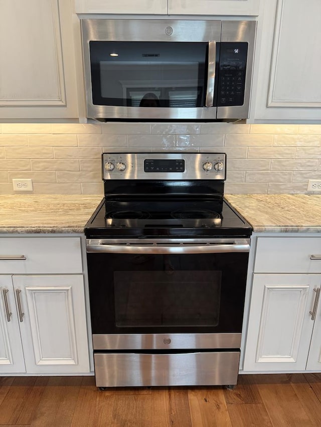 564 Osprey Cir, Tifton, GA 31794 - kitchen with stainless steel appliances, white cabinets, backsplash, and light stone counters