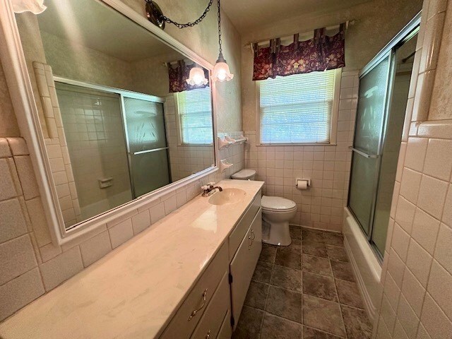237 Dewey Mcglamry Rd, Fitzgerald, GA 31750 - full bath with tile walls, vanity, and shower / bath combination with glass door