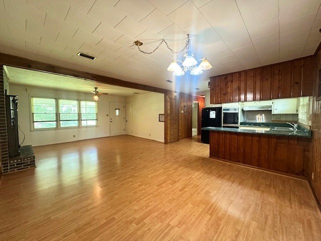 237 Dewey Mcglamry Rd, Fitzgerald, GA 31750 - kitchen with oven, under cabinet range hood, dark countertops, open floor plan, and light wood-style floors
