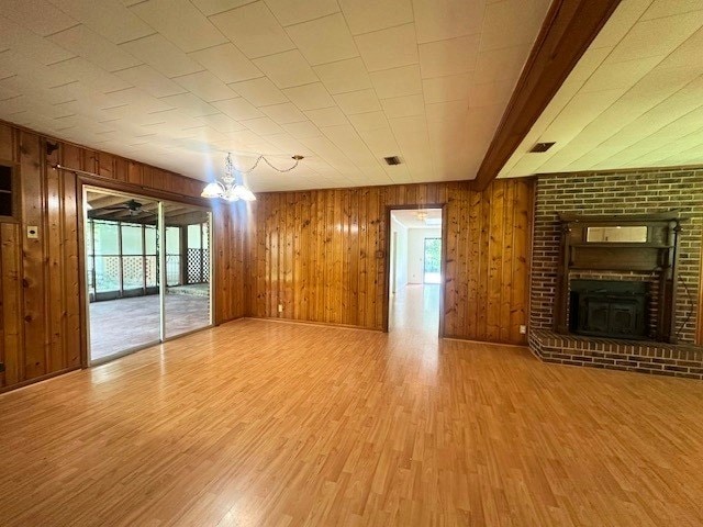 237 Dewey Mcglamry Rd, Fitzgerald, GA 31750 - unfurnished living room featuring wood finished floors, a fireplace, and wooden walls