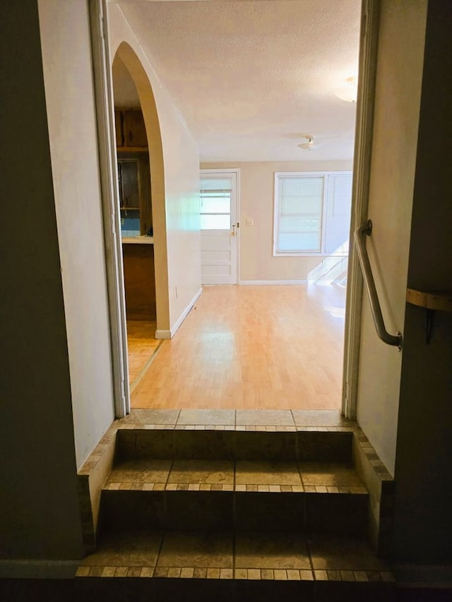 358 Camp Brooklyn Rd, Fitzgerald, GA 31750 - staircase featuring wood finished floors, a textured ceiling, baseboards, and arched walkways