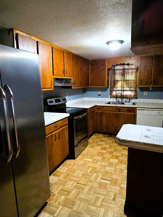 358 Camp Brooklyn Rd, Fitzgerald, GA 31750 - kitchen featuring appliances with stainless steel finishes, a sink, under cabinet range hood, tile countertops, and brown cabinets