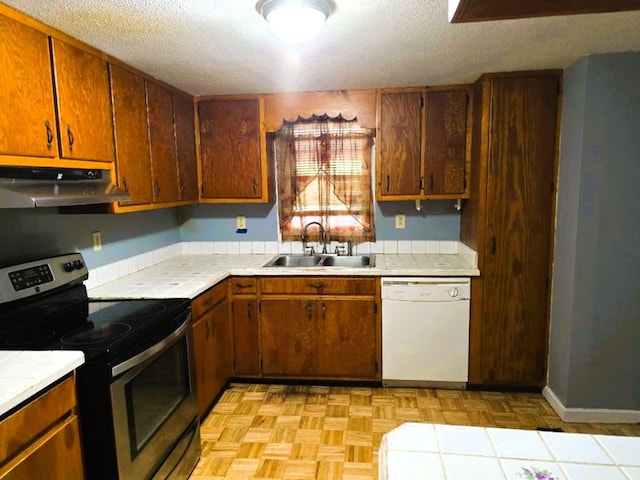358 Camp Brooklyn Rd, Fitzgerald, GA 31750 - kitchen with dishwasher, stainless steel range with electric cooktop, a sink, tile counters, and under cabinet range hood