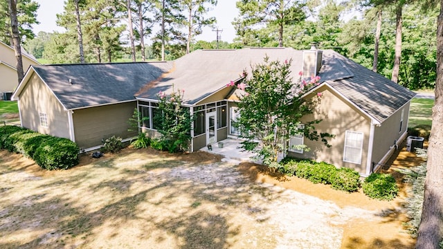 218 Sutton Rd, Tifton, GA 31794 - view of front facade with a chimney, a sunroom, a shingled roof, and view of scattered trees