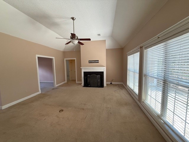 218 Sutton Rd, Tifton, GA 31794 - unfurnished living room with a ceiling fan, a fireplace with flush hearth, light carpet, and lofted ceiling