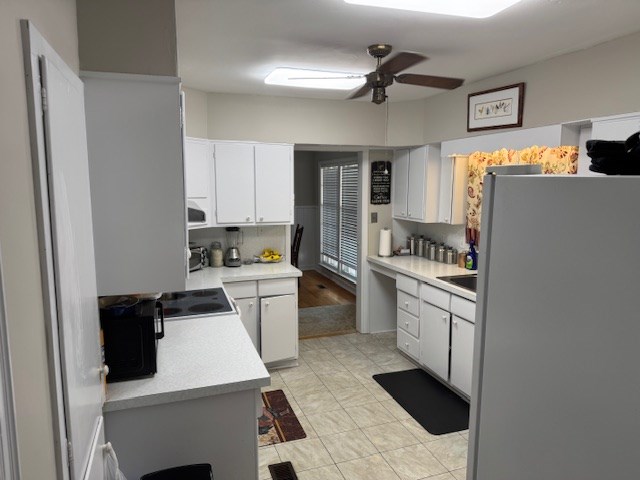 602 20th St, Tifton, GA 31794 - kitchen with white cabinets, light countertops, a ceiling fan, white appliances, and backsplash