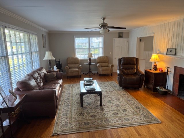 602 20th St, Tifton, GA 31794 - living room featuring a tiled fireplace, a ceiling fan, crown molding, and wood finished floors