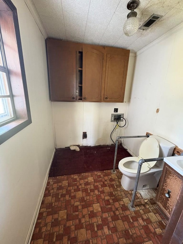 laundry area featuring ornamental molding, cabinet space, hookup for a washing machine, and visible vents