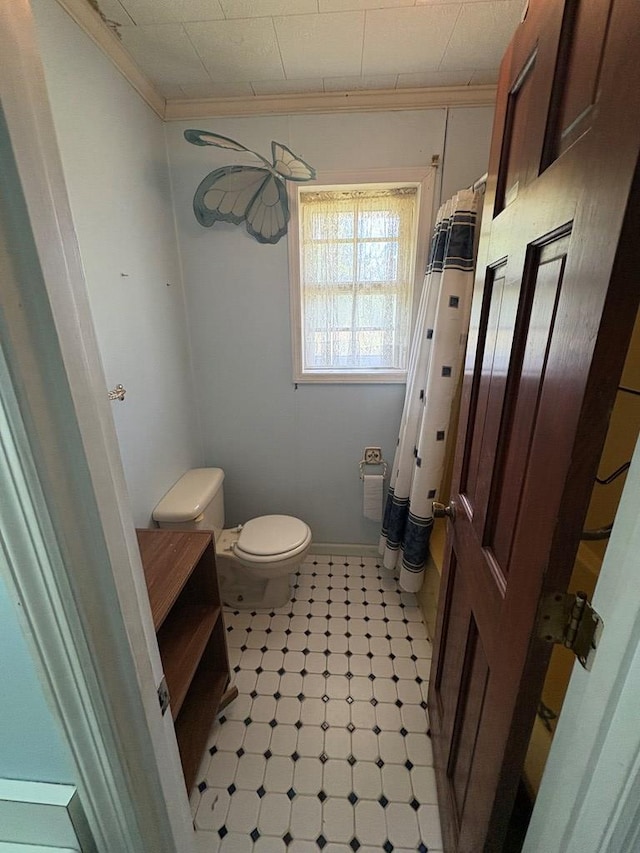 bathroom with crown molding, tile patterned floors, toilet, and curtained shower