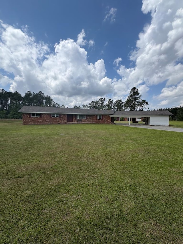 view of front of house with concrete driveway, a front yard, and a carport