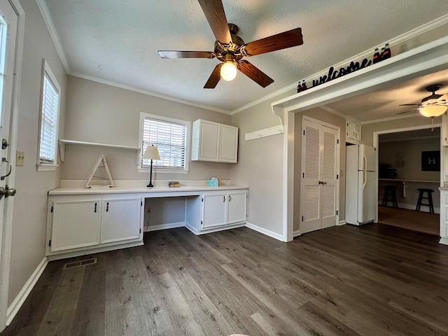 kitchen featuring visible vents, freestanding refrigerator, built in study area, ceiling fan, and dark wood-style floors