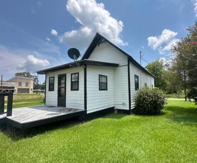 back of property featuring a lawn and a deck
